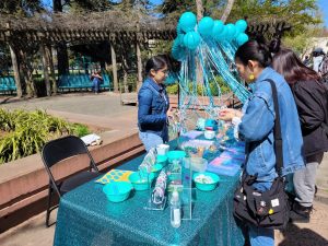 Students making bracelets at a table run by student volunteers in the Library Quad Tuesday, April 4, 2023. The Office for Equal Opportunity held a tabling event which will continue  every Tuesday through the end of the month to celebrate Sexual Assault Awareness Month.