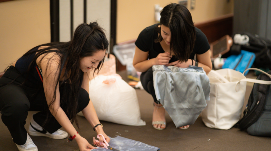 (L-R) Fashion merchandising and management majors Joanne Lee and Sophy Xiong put the final touches on Lees dress design at the Forces of Nature dress rehearsal Thursday, April 13, 2023. Designers picked from one of four elements for inspiration: fire, water, earth and air.