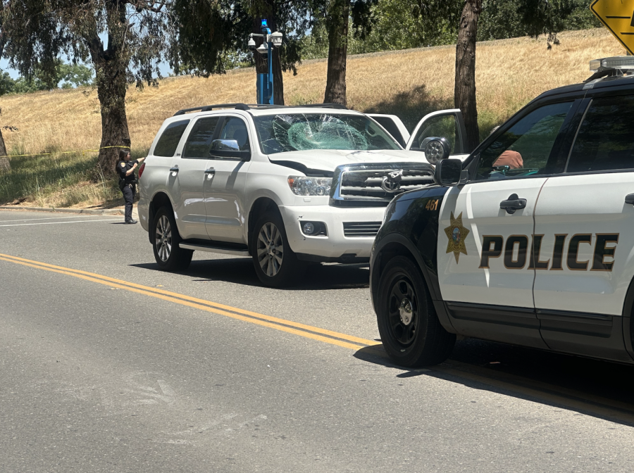 A white SUV with a shattered windshield on State University Drive near Sequoia Hall after colliding with a cyclist Saturday morning, May 27, 2023. A Sacramento State police officer said the victim was pronounced dead at the scene.