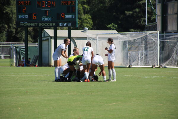 Sacramento State’s womens soccer team celebrates with Abigail Lopez after her goal Sunday, Sept. 10, 2023. Lopez slid past the goalkeeper after smoothly intercepting a pass back from Pacific defenders, scoring the second Hornet goal.