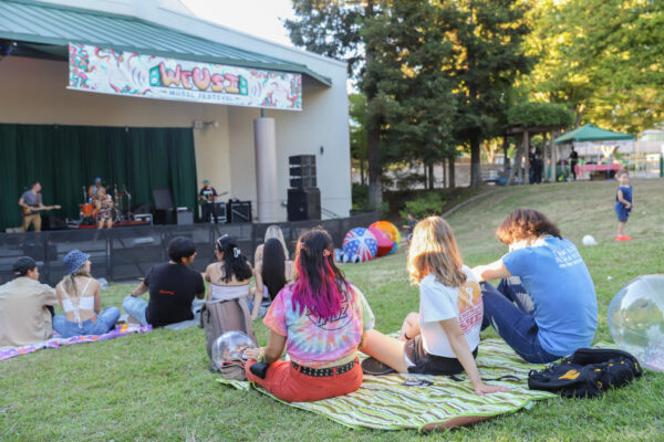 Sac State students sit and watch the first WEUSI music festival at Serna Plaza Saturday, Sept. 24, 2022. This was the first WEUSI music festival UNiQUE Programs has hosted ever at Sacramento State. 
