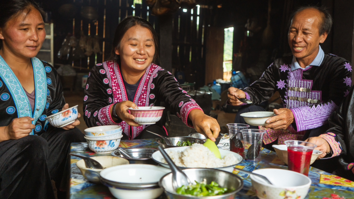 A+Hmong+family+dressed+up+in+traditional+Hmong+clothing+sharing+a+meal+together.+Sharing+a+meal+brings+Hmong+families+together+as+it+symbolizes+not+only+nourishment+but+the+sharing+of+stories+and+traditions.+%28Photo+courtesy+of+Canva%29