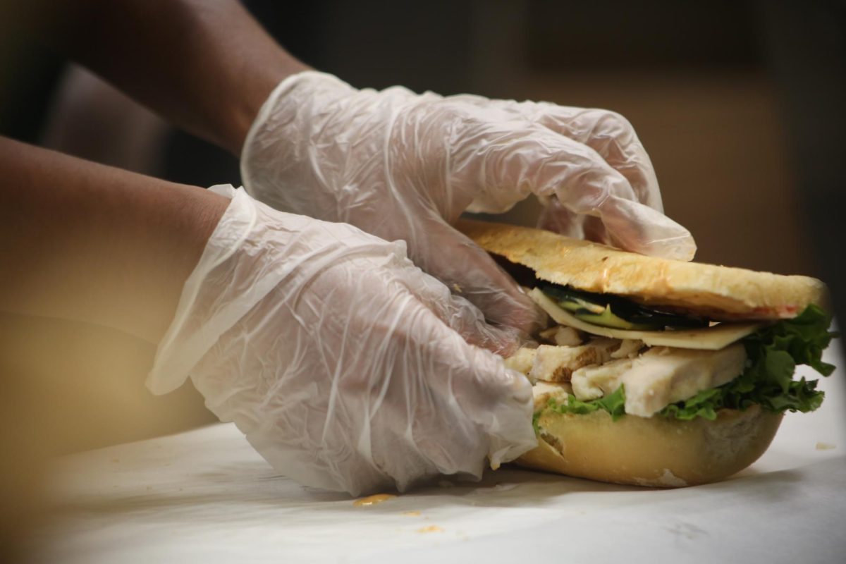 A Good Eats! worker makes a sandwich for a Sac State student at the University Union Monday, Oct. 16, 2023. Featured here is a chipotle chicken club on sourdough bread. (Photo by: Alyssa Branum)