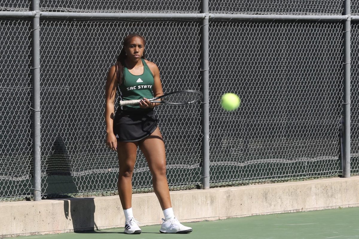 Freshman Women’s Tennis player Reese Walker watches her teammate during a match at the Sac State Tennis Courts Saturday, March 16, 2024. The team won 4-3 against Weber State, Walker won singles score of 6-2.