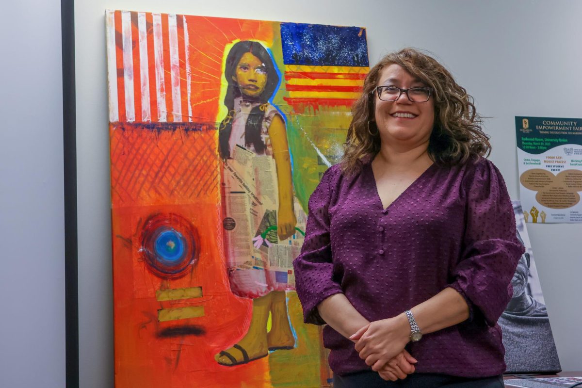 Department of Ethnic Studies professor and CHLFSA Board member Elvia Ramirez stands by the mural at the Center on Race, Immigration & Social Justice Wednesday, Sept. 11, 2024. Though she serves as coordinator for the CRISJ mentorship program, Ramirez also dedicates her time to the Chicanx/Latinx Faculty Staff Association.  