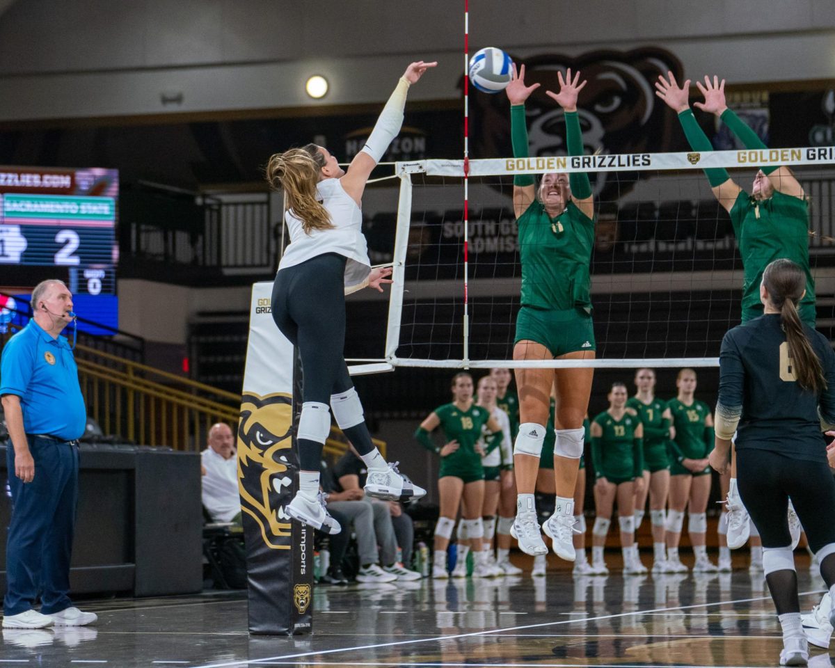 Senior outside hitter Ellie Tisko and sophomore middle blocker Karlie Spohn go up to block the potential kill by Oakland Friday, Sept. 13, 2024. The Hornets won the match 3-0.