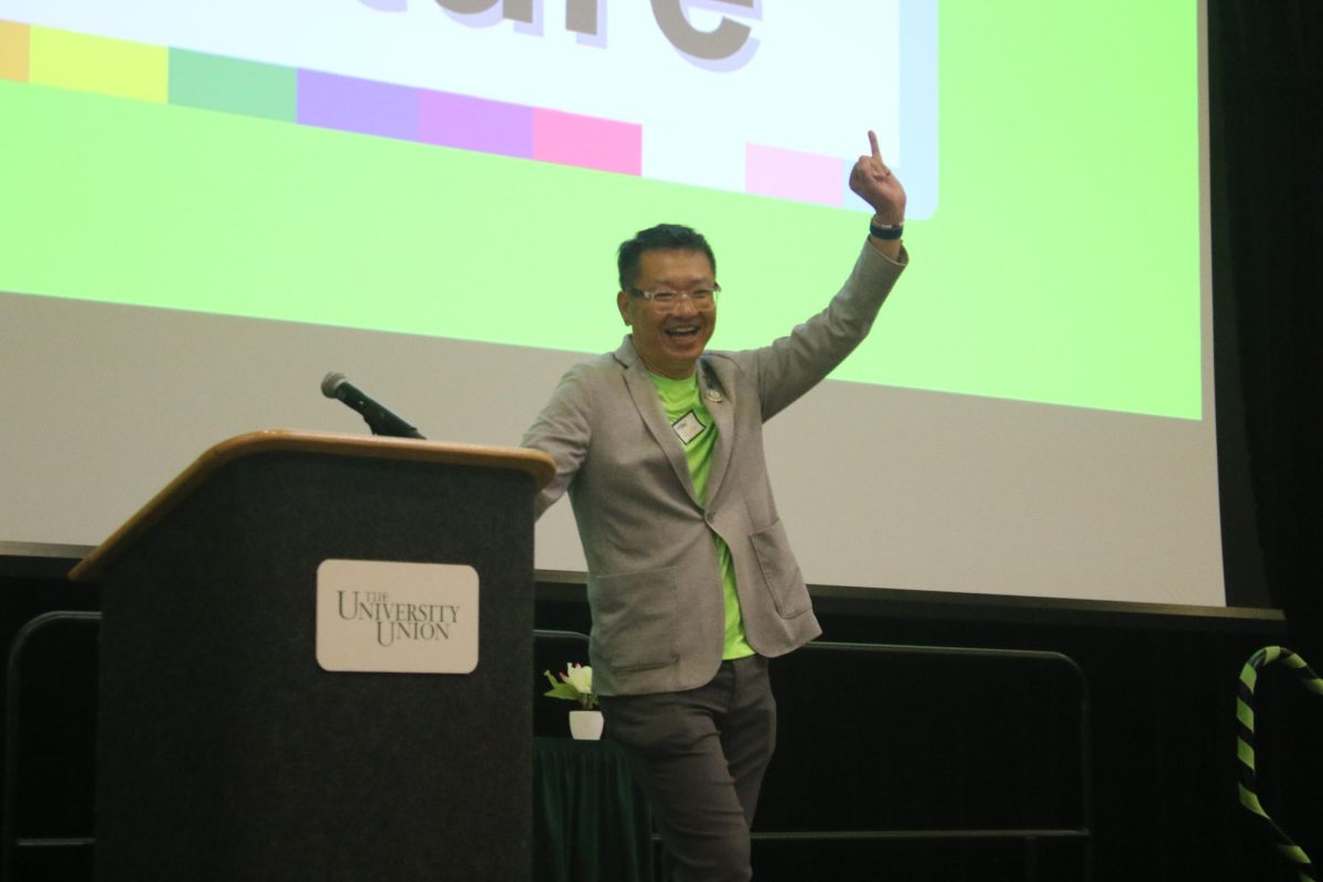 New Pride Center Coordinator, Hei Fok, in the University Ballroom on Sep. 8. 2024. Hei Fok does a ‘stingers up’ gesture to celebrate being a Sac State alum and now coordinator of the expanded center.