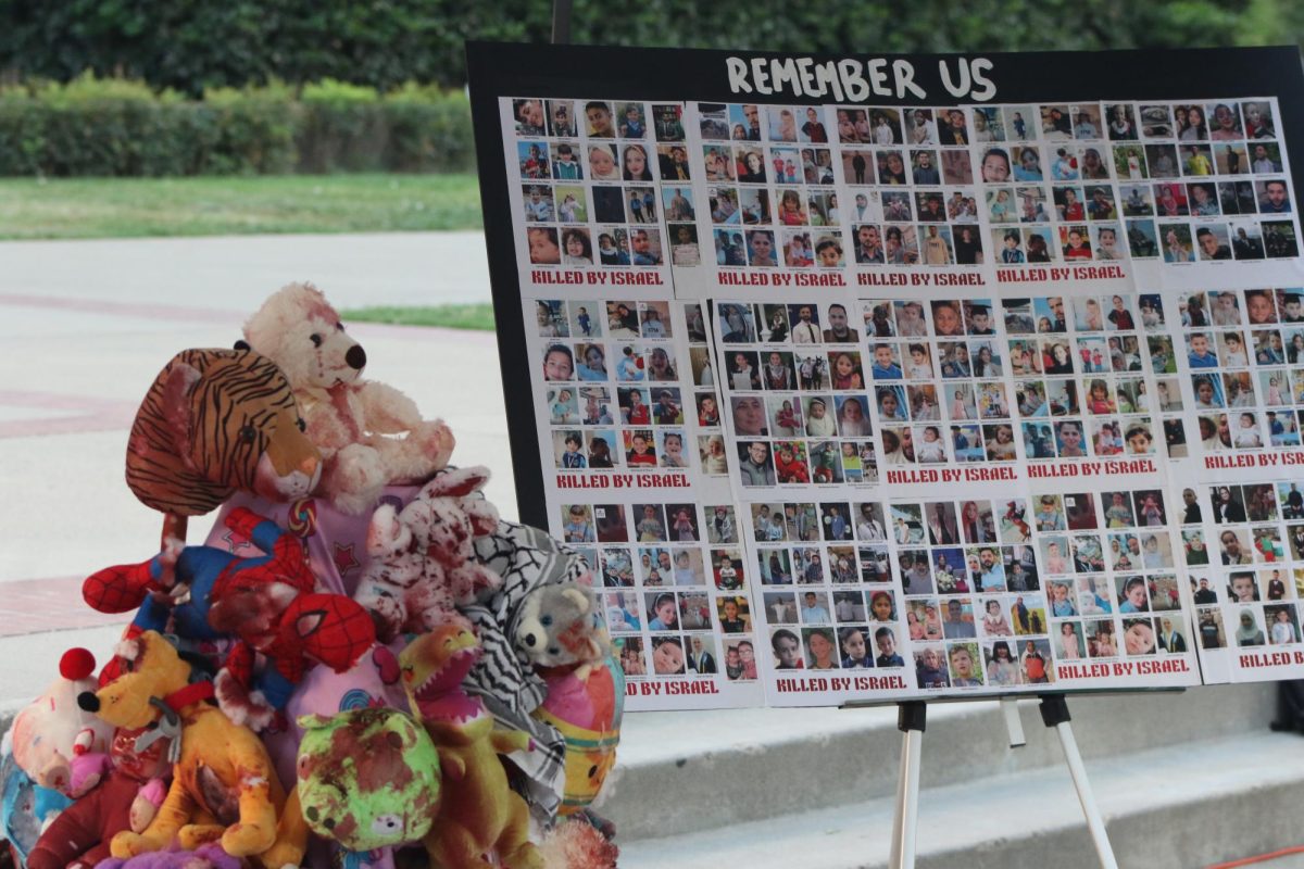 A pile of stuffed animals painted with red paint to resemble blood sits next to a large sign depicting images of those who have died in the Israeli-Palestinian conflict that began Oct. 7, 2023. The display was part of the third section of the art exhibit “Let It Be A Tale” held at the California State Capitol.