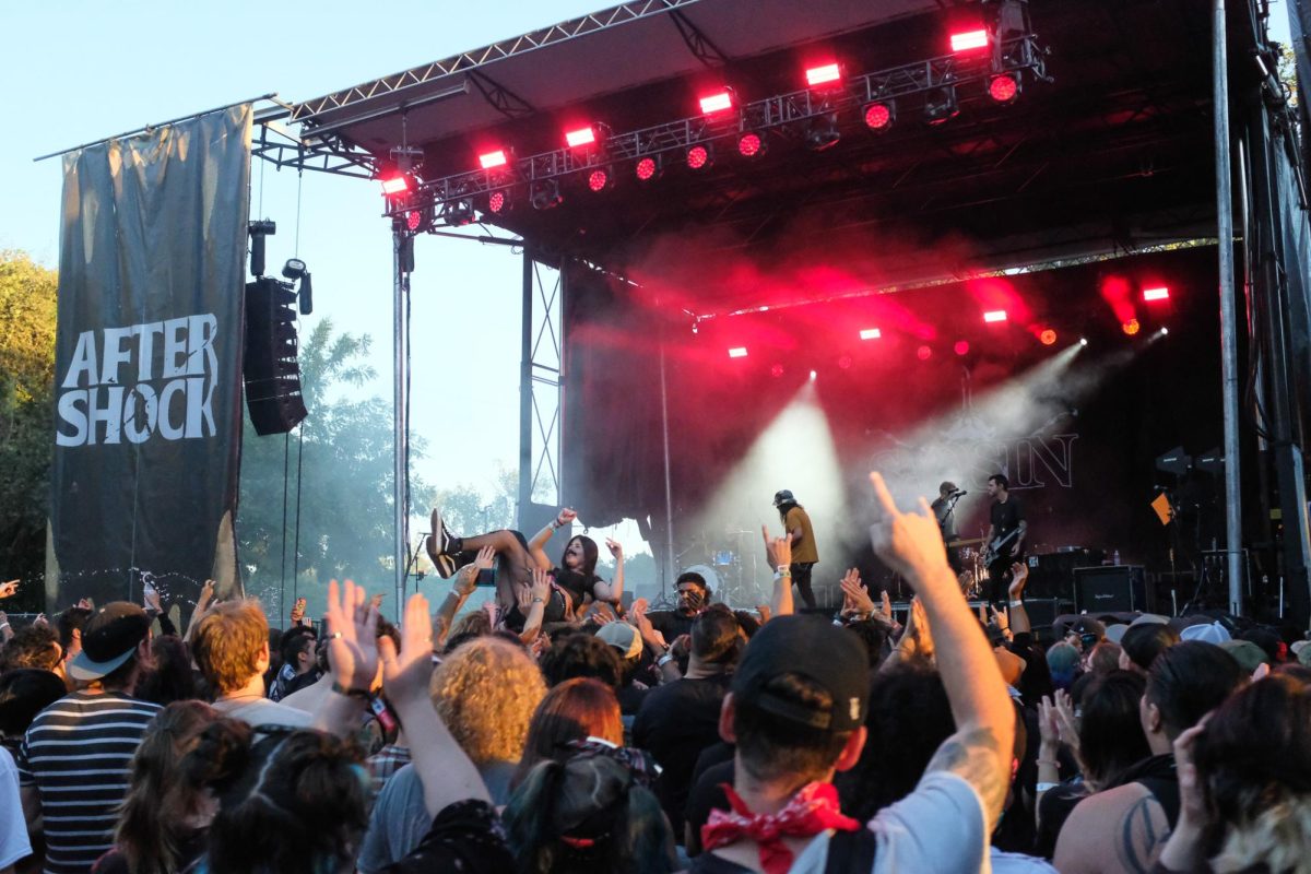 Emo band Saosin performs on the Soundwave stage while an attendee crowd surfs atop a cheering audience at Aftershock festival in Discovery Park on Saturday, Oct. 12. Crowd surfers would be carried to the front of the barricade where festival security would pick up and escort them back to the crowd.