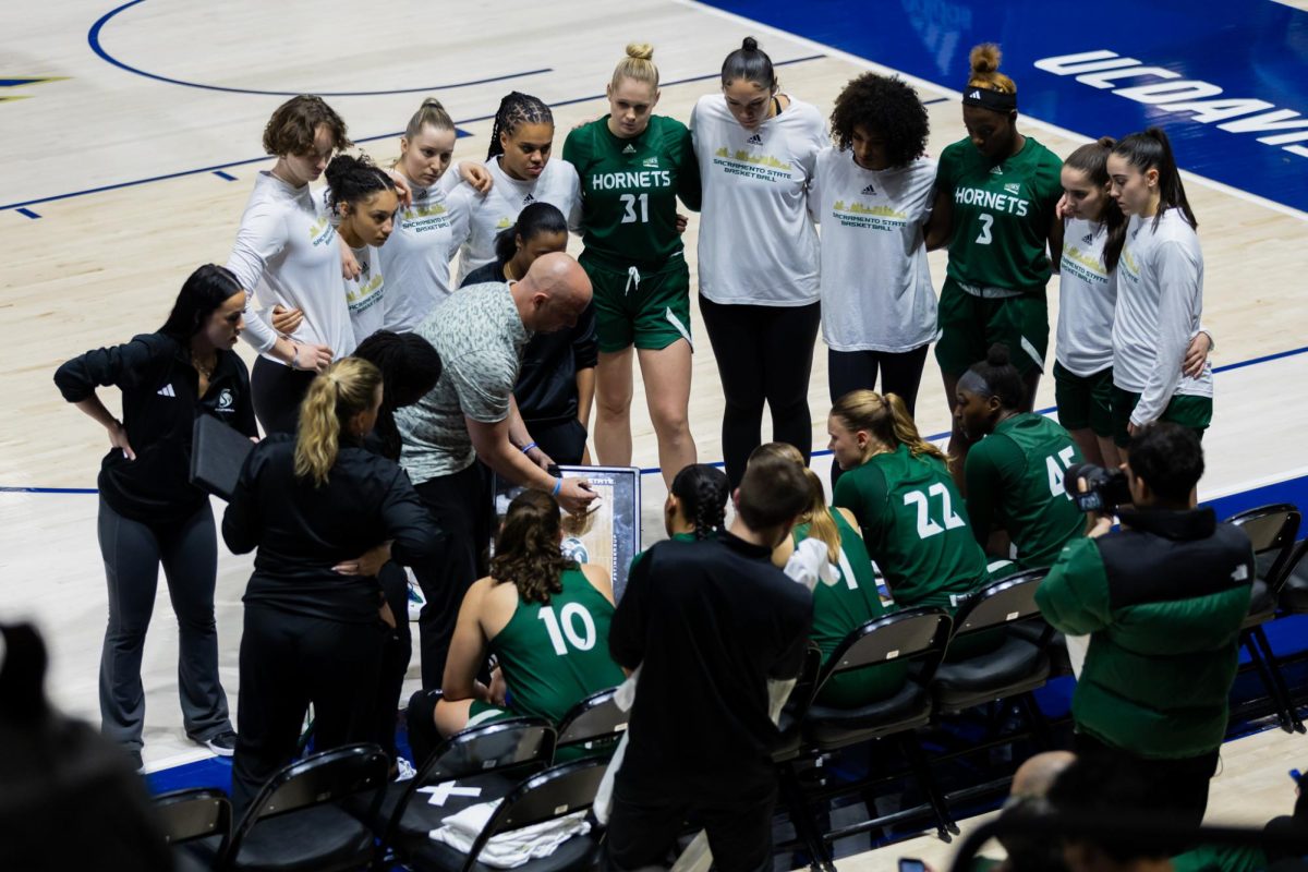 Sacramento State huddles around head coach Aaron Kallhoff during a timeout against University of California, Davis Wednesday, Nov. 20, 2024. The Hornets are 5-3 on the season after a blowout win in their recent matchup.