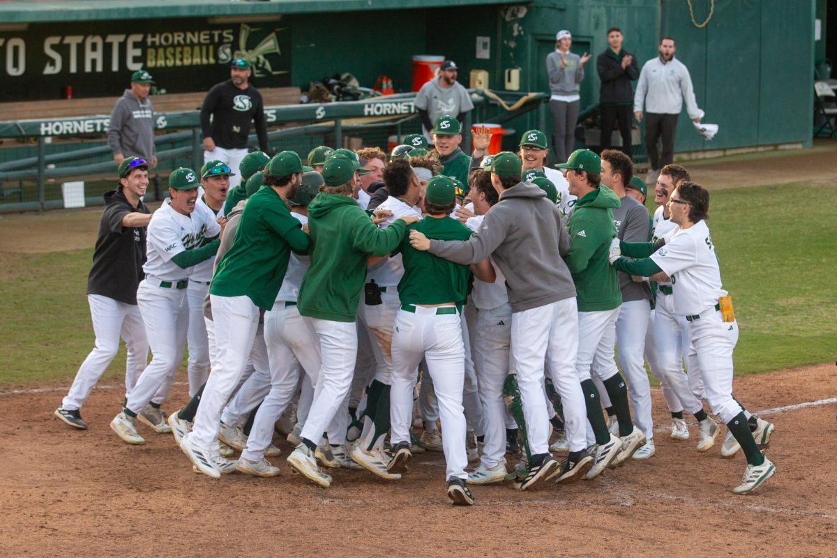 The Hornets gather around junior outfielder Ryan Christiansen in triumph after he hit a walkoff home run in their first doubleheader game against Ball State Friday, Feb. 21, 2025. With a runner on base, Ryan Christiansen’s hit set the Hornets up to steal the lead and immediately win the game, tying the 4-game series 1-1.