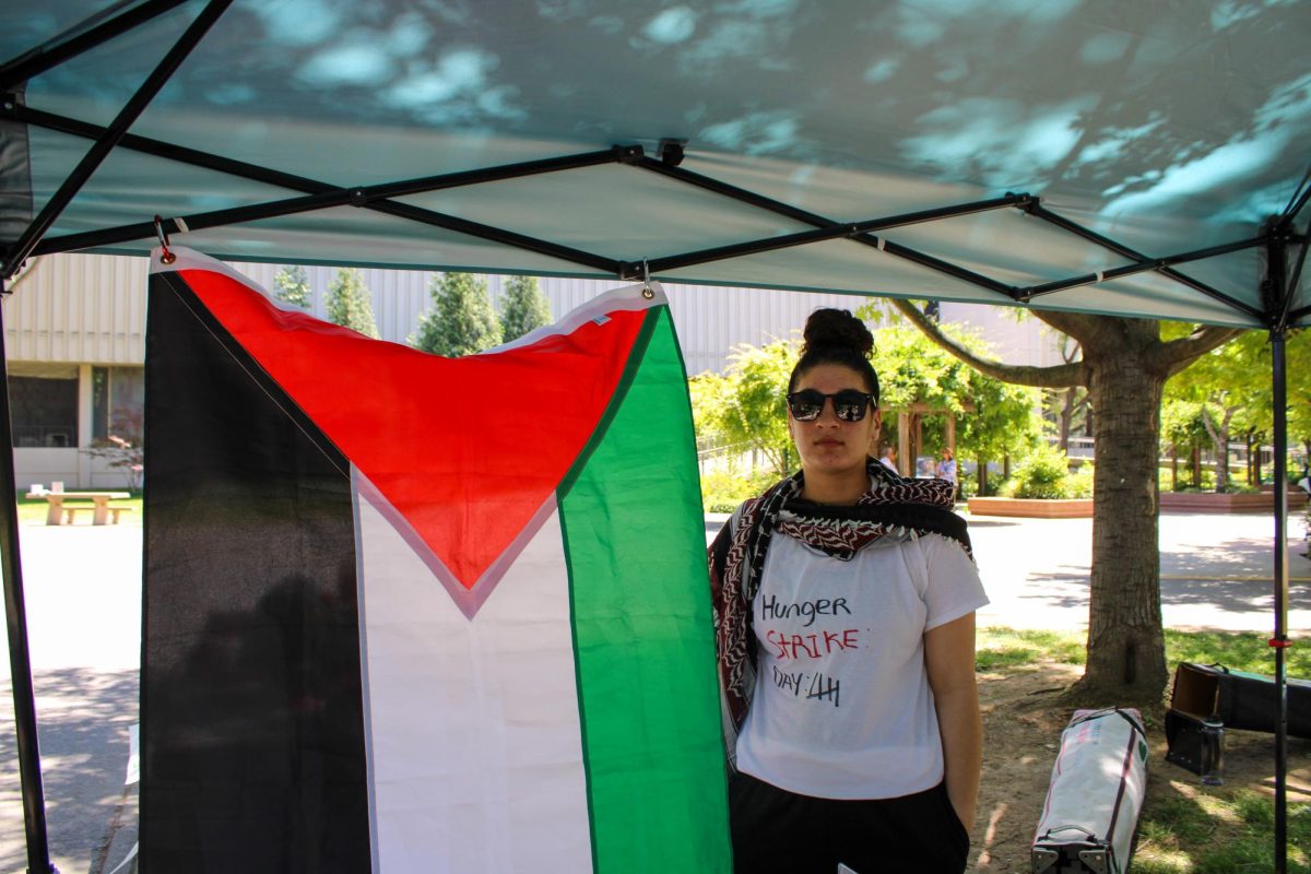 Samira Mahmoud stands next to the Palestinian flag Friday, May 5, 2025. Mahmoud is partaking in the hunger strike and is currently on day 5, as of May 9.