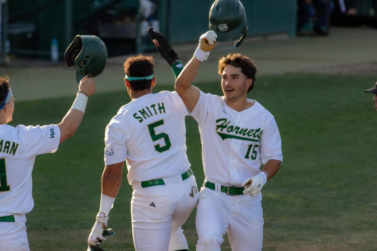 Redshirt sophomore Jakob Poturnak clinks helmets with his teammates Thursday, April 17, 2025. Poturnak had 10 hits, including a home run, over the 3-game series against GCU.