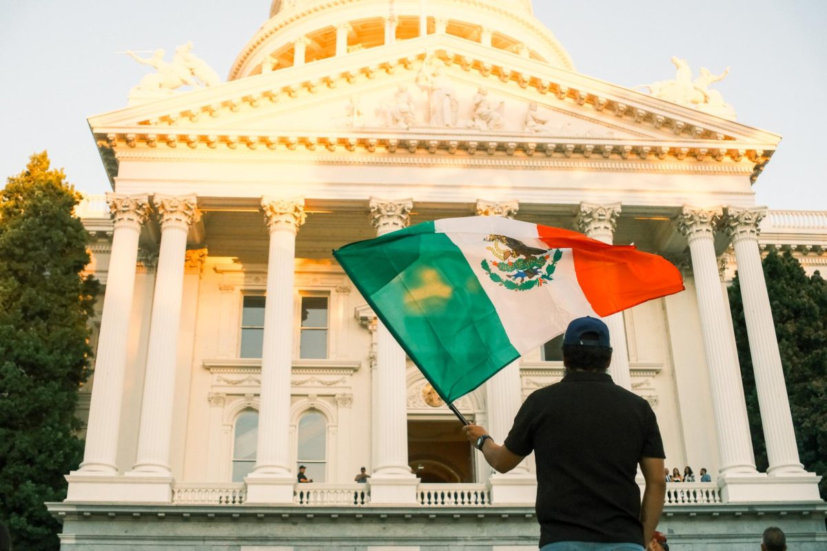 Hombre con su bandera Mexicana en la ceremonia para el Grito de independencia en frente del Capitolio de Sacramento, lunes 15 de septiembre, 2025. 