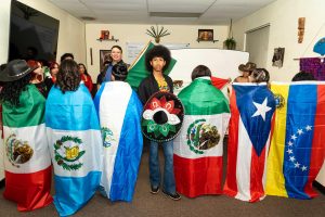 Jamarie Crawford posa con banderas de campo latinas en el aula de Casa de Español el 22 de marzo de 2025. Crawford creó su sesión de fotos "Latinos Unidos" para demostrar la capacidad de recuperación latina. (Foto de Ramon Rodriguez)