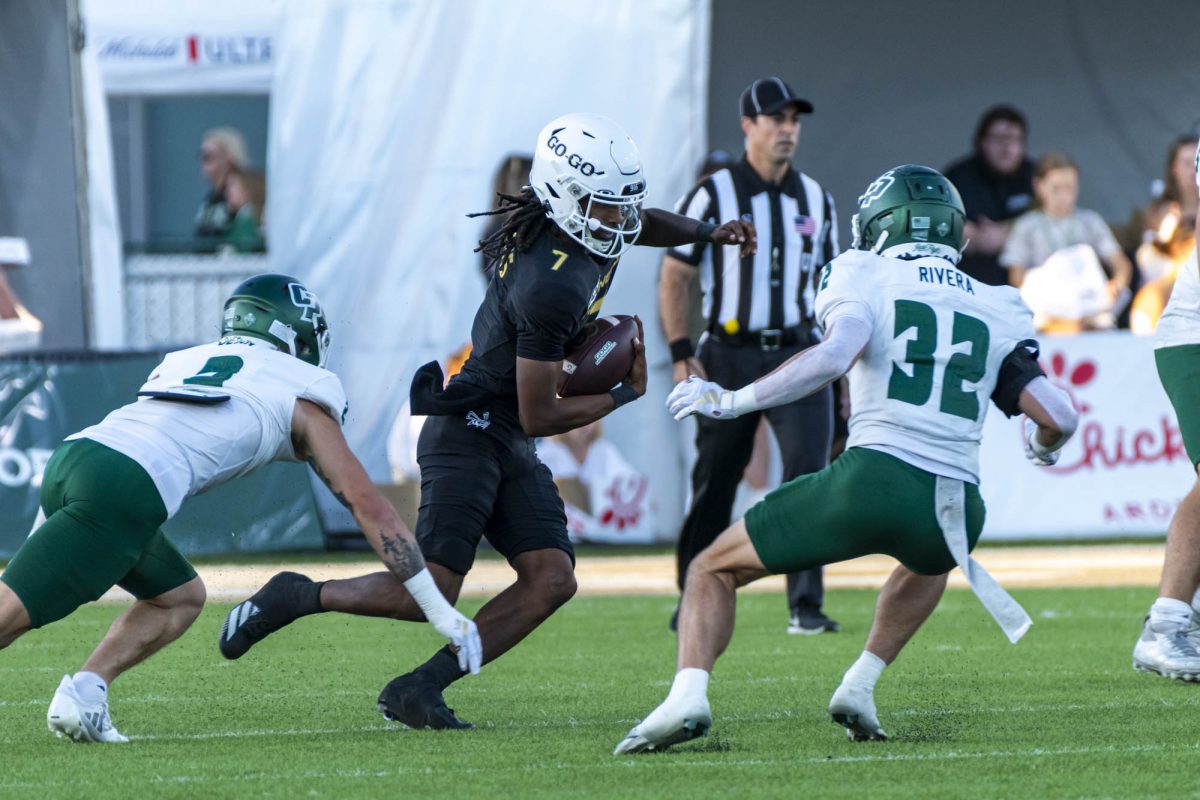 Junior quarterback Cardell Williams dances between defenders Saturday, Sept. 27, 2025. Williams threw three interceptions, one of which was returned for a touchdown.