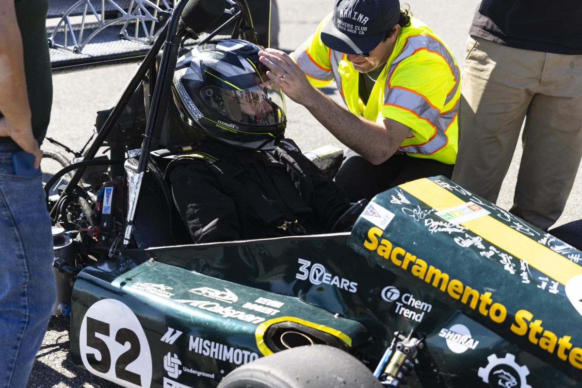 Senior mechanical engineering major John Anderson (right) gives second-year mechanical engineering major Kyle Clemons (left) last minute instructions Saturday, Oct. 11, 2025.  Clemons was one of the drivers for Hornet Racing that raced on the small skid-pad at Thunderhill Raceway in Willows. 