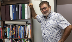 Professor Clovis Karam posing by the bookshelf in his office Thursday, Sept. 25, 2025. Karam is always doing research, furthering his own education.
