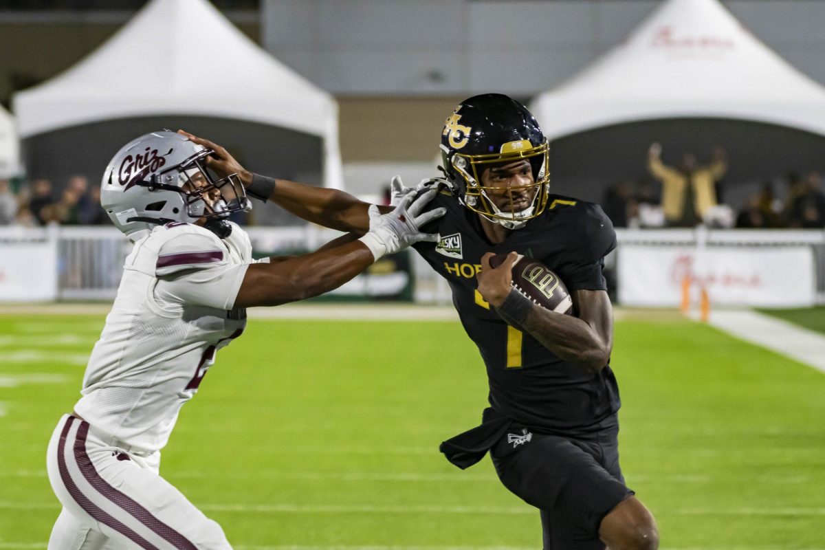 Junior quarterback Cardell Williams stiffarms a defender, as he reaches for more yards after contact against Montana Friday, Oct. 24, 2025. Williams had a big night, eclipsing a new career high in passing yards with 335 passing yards and finishing the game with three total touchdowns. 