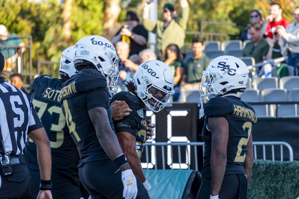 Senior Sam Adams II, sophomore Damian Henderson II and senior Rodney Hammond, Jr who all embrace after a running back pass touchdown from Hammond, Jr to Adams II against Cal Poly Saturday, Sept. 27, 2025. The trio, Sacramento State’s three-headed monster at the running back position, helped contribute 230 rushing yards in a loss versus Cal Poly.