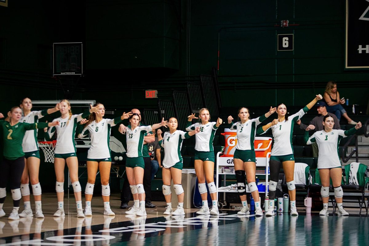 The Hornet bench holds up their imaginary bow and arrows like archers during a game against Eastern Washington Saturday, Oct. 25, 2025. Sacramento State’s volleyball team had won all three sets, which marked their 700th win since joining the Division I ranks in 1991.